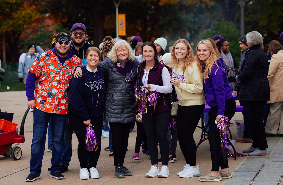 A group of UNI alumni, students and friends of all ages smiling at UNI Homecoming 2022