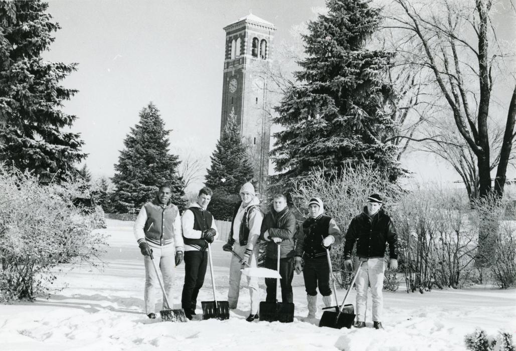 UNI students standing in the snow with shovels in front of the Campanile
