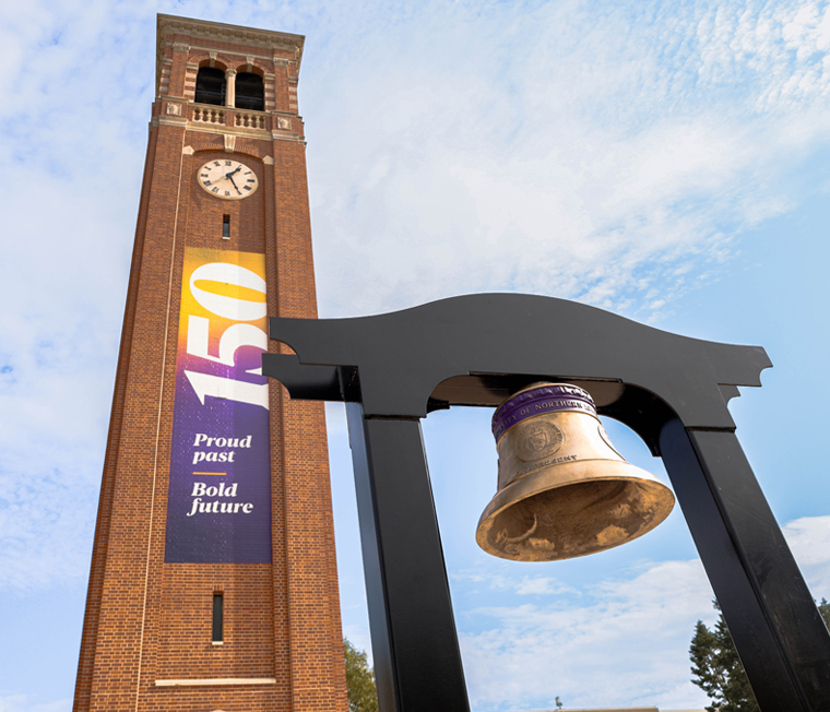 UNI's Sesquicentennial Bell on the Campanile Plaza in front of the Campanile with a 150 banner