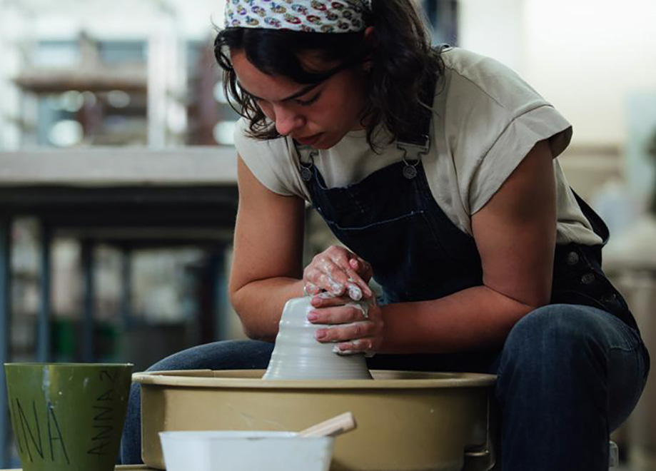 Anna Gilbreath in an art studio shaping clay
