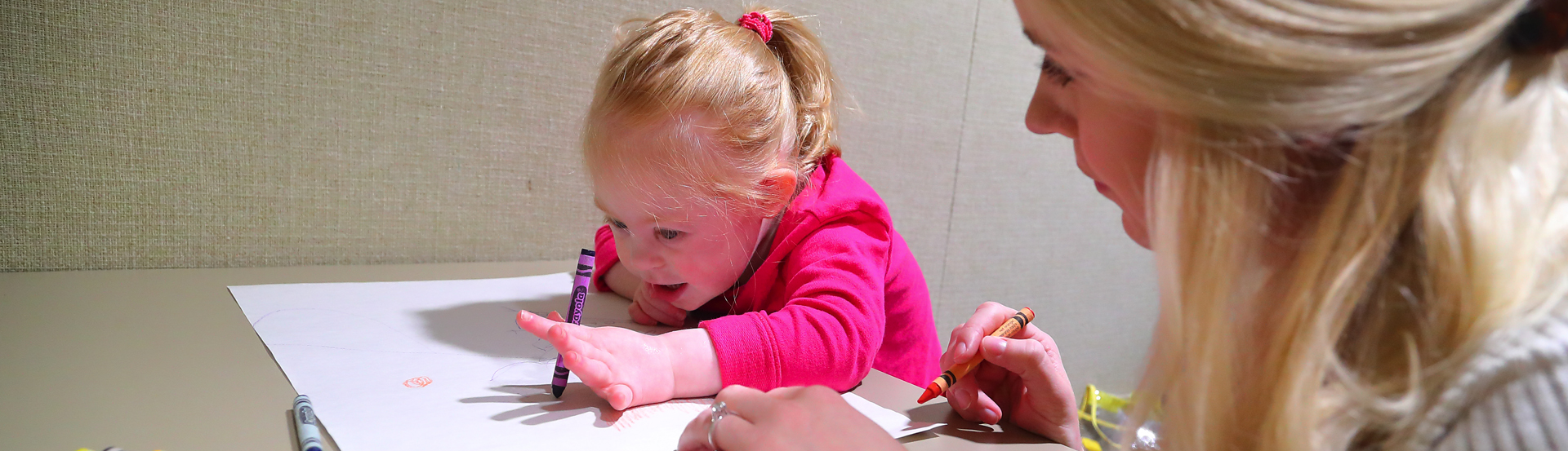 A young girl colors during a speech therapy session with a UNI student clinician at the Roy Eblen Speech & Hearing Clinic