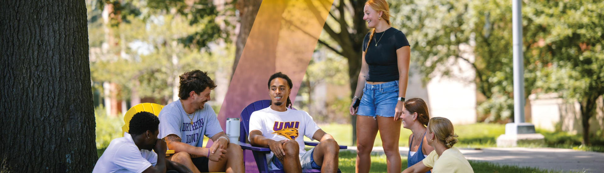 Six students sitting outside talking and laughing.