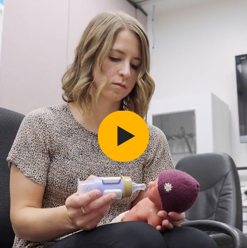 Video play button-UNI student Anna Wanninger with an infant manikin
