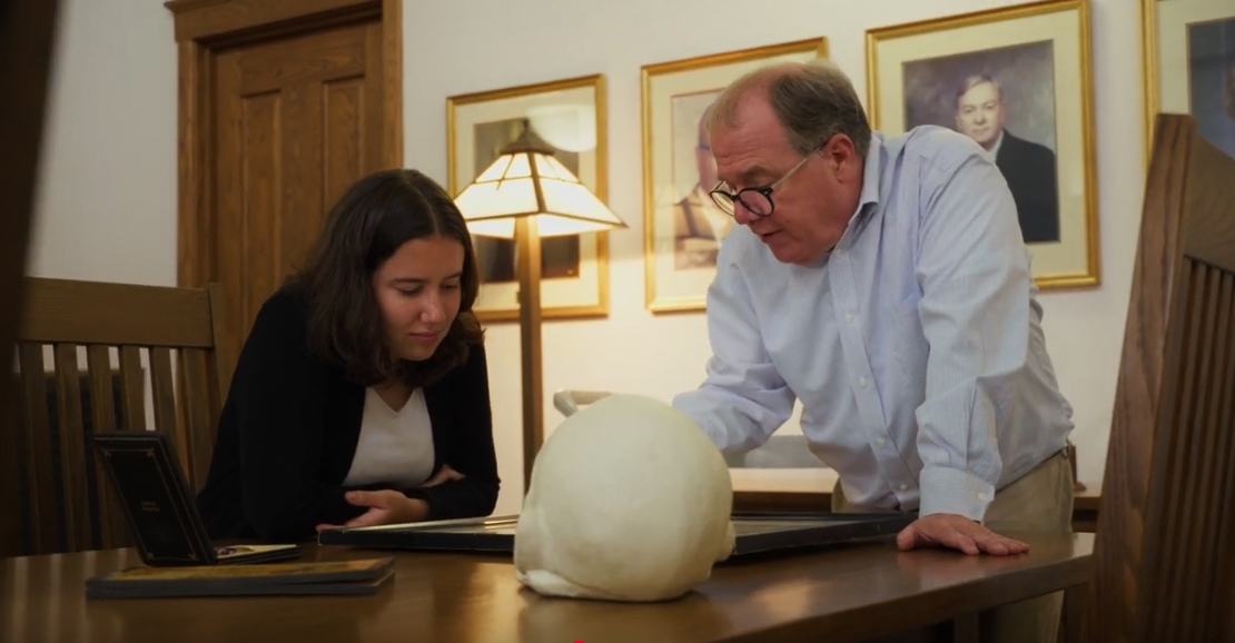 A UNI student and professor examine objects in UNI's Great Reading Room