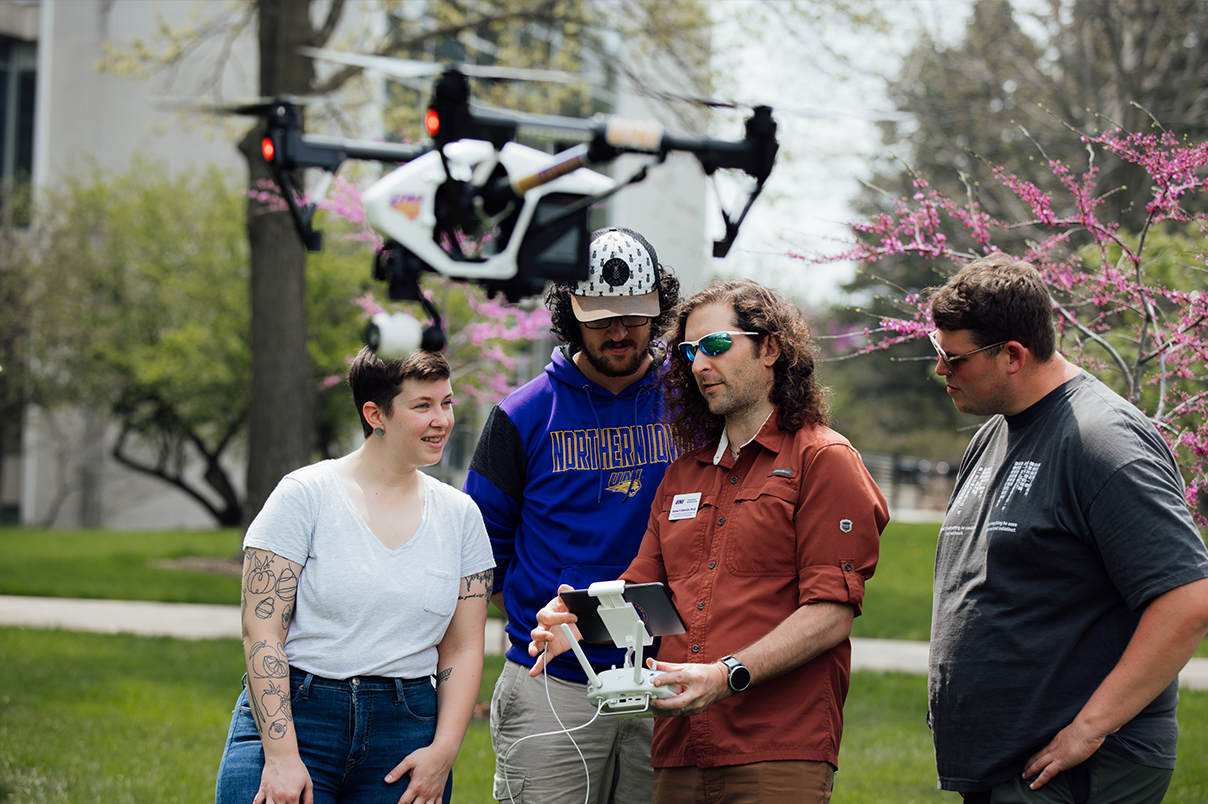 UNI geogrpahy students flying a drone on campus