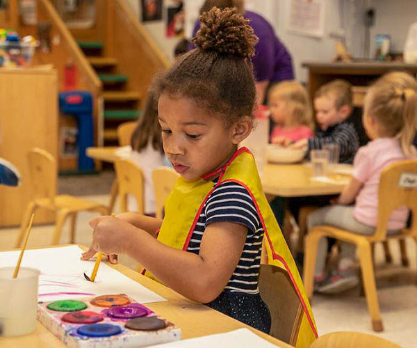 Young child painting in the Early Childhood Education Center