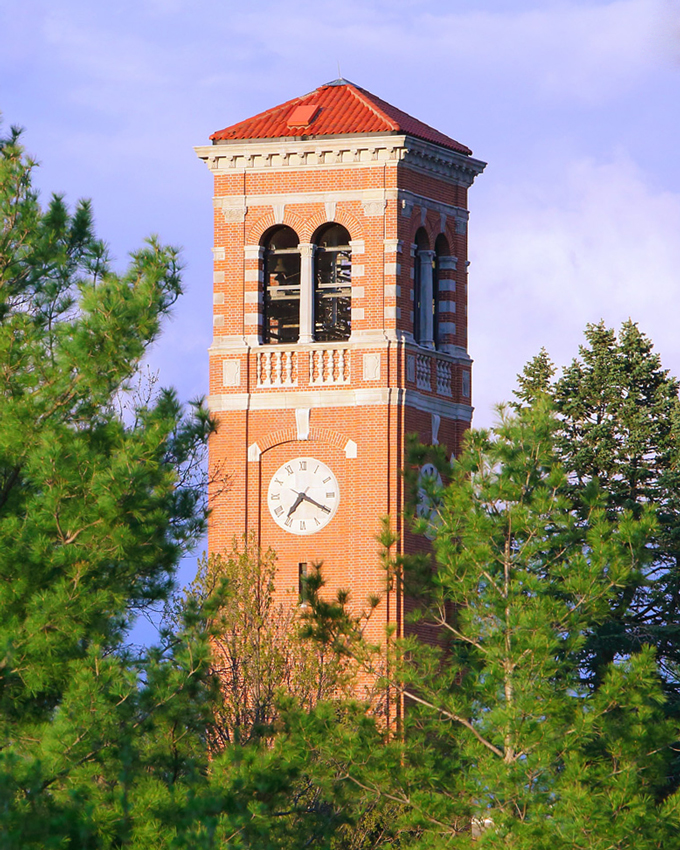 the UNI Campanile showing between trees on UNI's campus