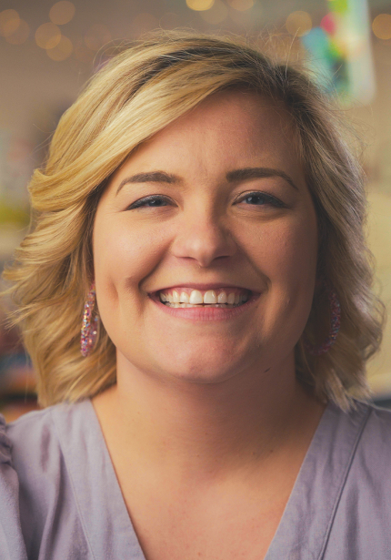 White woman with blonde hair smiling at the camera.